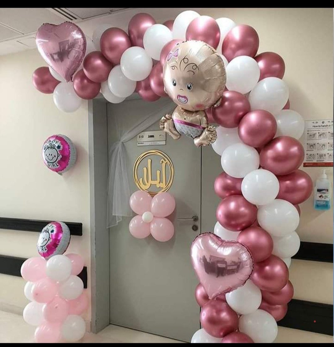 Pink and white balloon arch welcoming a baby girl